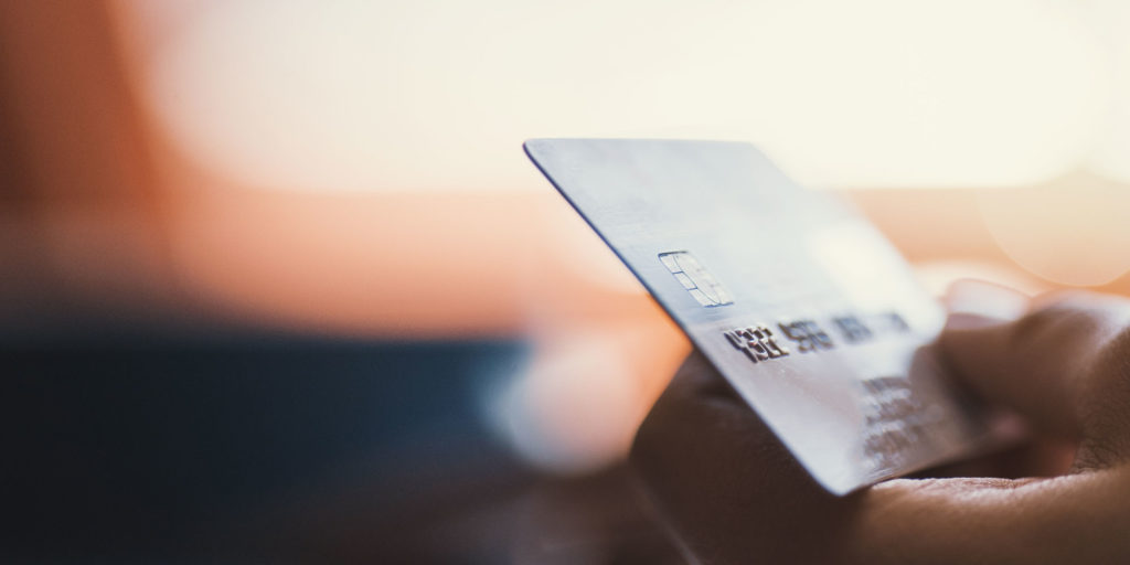 Hand holding a credit card to pay for dental procedure