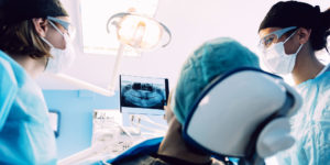 dentist-performing-full-mouth-dental implants procedure