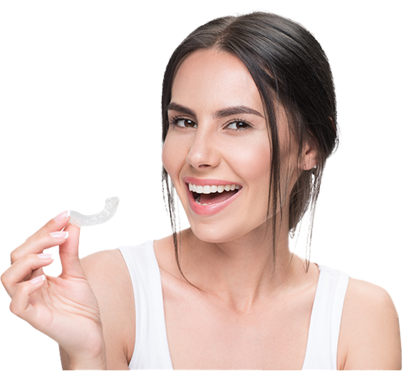 Smiling woman holds a dental aligner in a white tank top, showcasing her confident Smile Now.